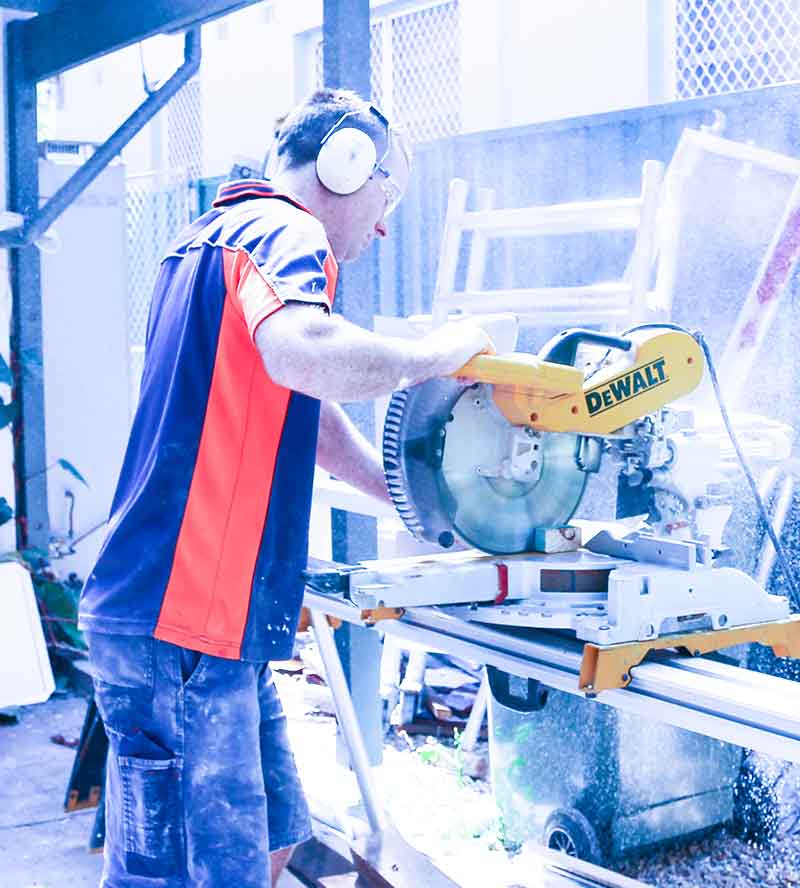 builder cutting timber with a drop saw